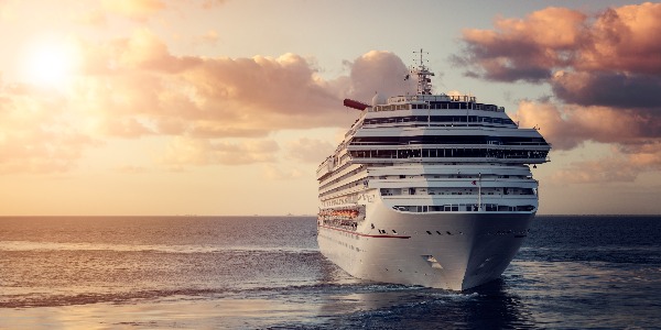 Luxury cruise ship leaving port at sunset
